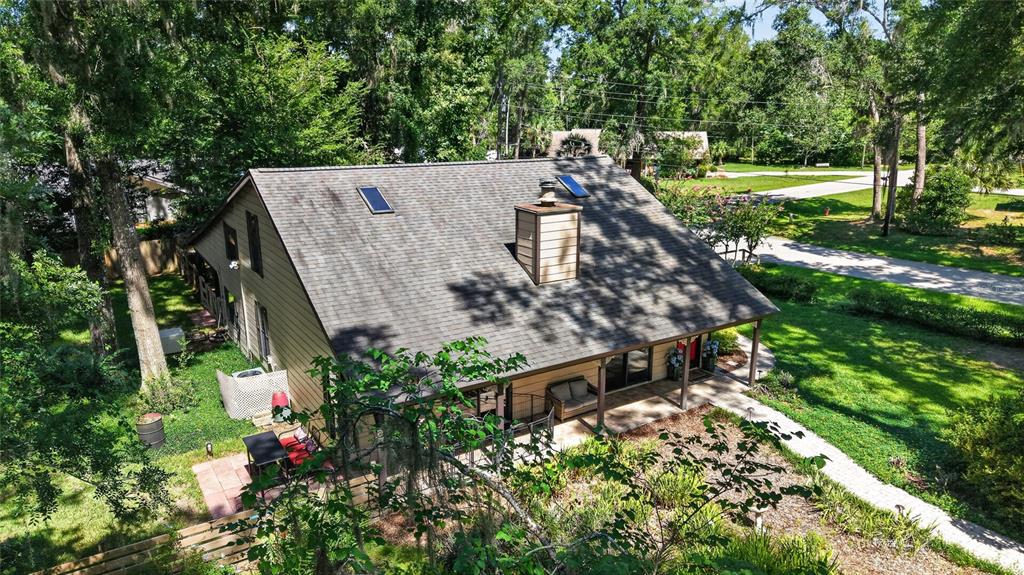 An aerial view of a house with a shingled roof, chimney, and covered porch — 3936 SE 23RD TERRACE, OCALA, FL