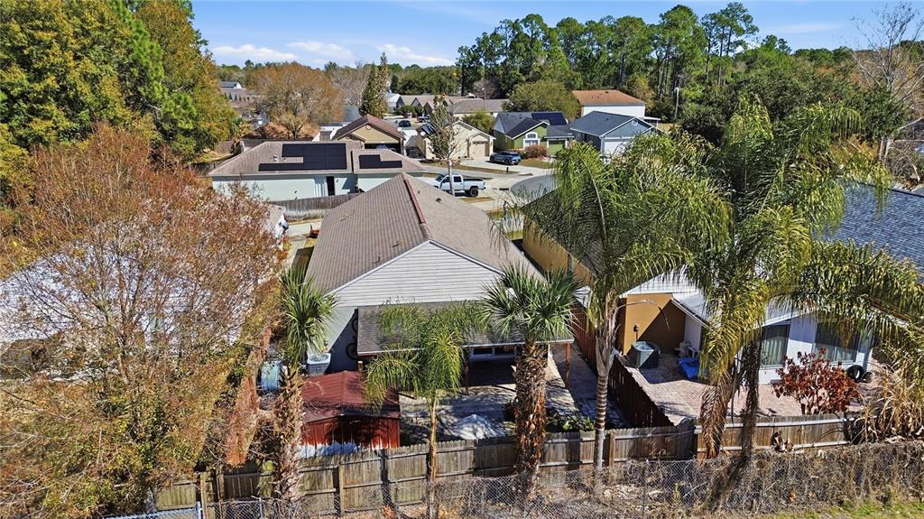 An aerial view shows the backyards and roofs of several suburban houses with palm trees — 139 PLACID WOODS COURT, SANFORD, FL
