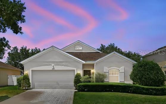 A single-story house with a two-car garage, light-colored stucco exterior, and a manicured front lawn — 2825 RUNNING BROOK CIRCLE, KISSIMMEE, FL