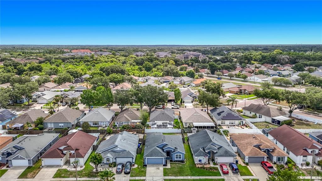 An aerial view shows a suburban neighborhood with single-family homes and surrounding green space — 1732 HULETT DRIVE, BRANDON, FL