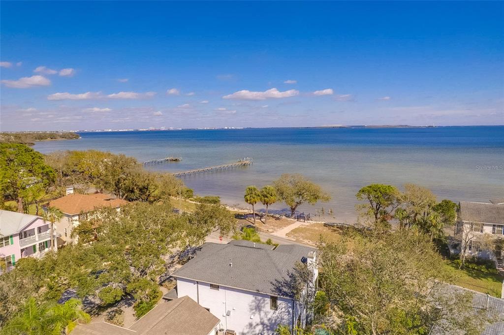 An aerial view shows a coastal house with a pier extending into the bay — 2802 NORTHPOINTE LANE, TAMPA, FL
