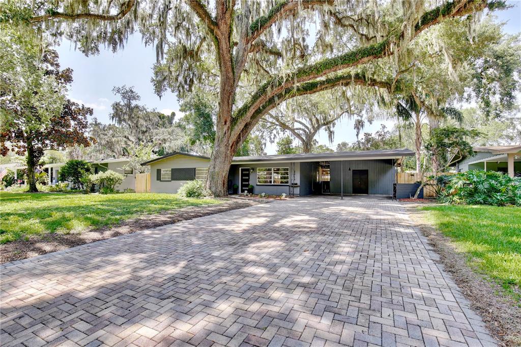 A single-story house with a paved driveway and large oak trees in the front yard — 2914 LANDO LANE, ORLANDO, FL