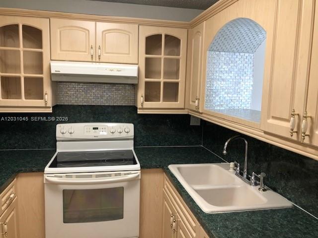 A kitchen features light wood cabinets, a white stove, and a dark green countertop — 6230 SW 129 PL # 1210, Miami FL 33183, MIAMI, FL