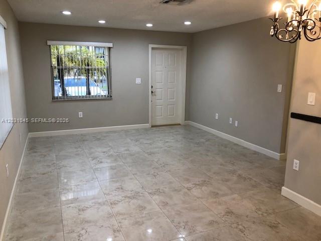 An empty room features light-colored tile flooring, a white front door, and a large window — 6230 SW 129 PL # 1210, Miami FL 33183, MIAMI, FL