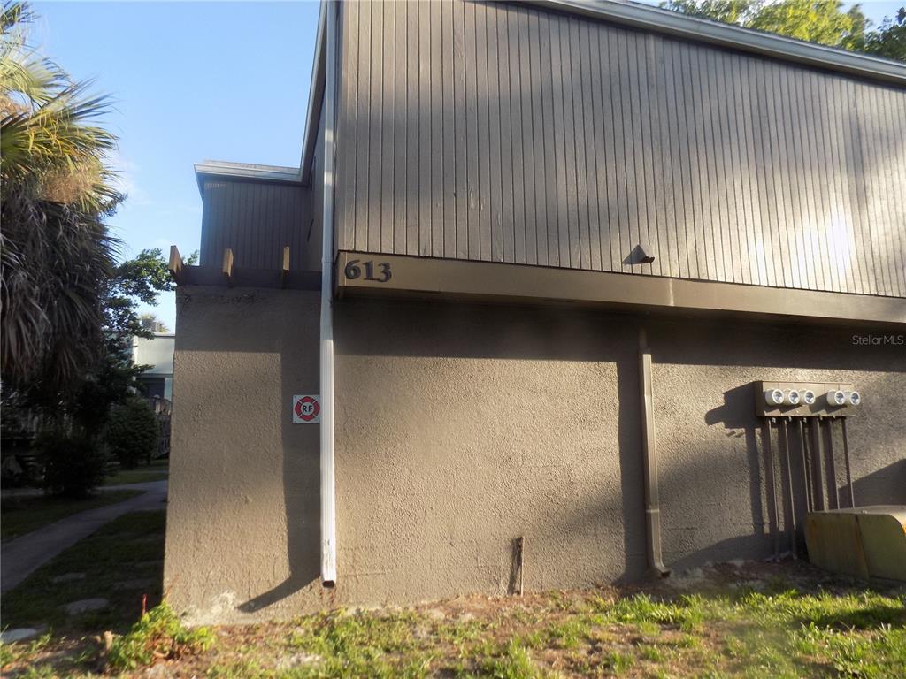 The exterior of a two-story building features vertical wood siding, stucco walls, and a downspout — 613 SW 75 STREET UNIT 101, GAINESVILLE, FL