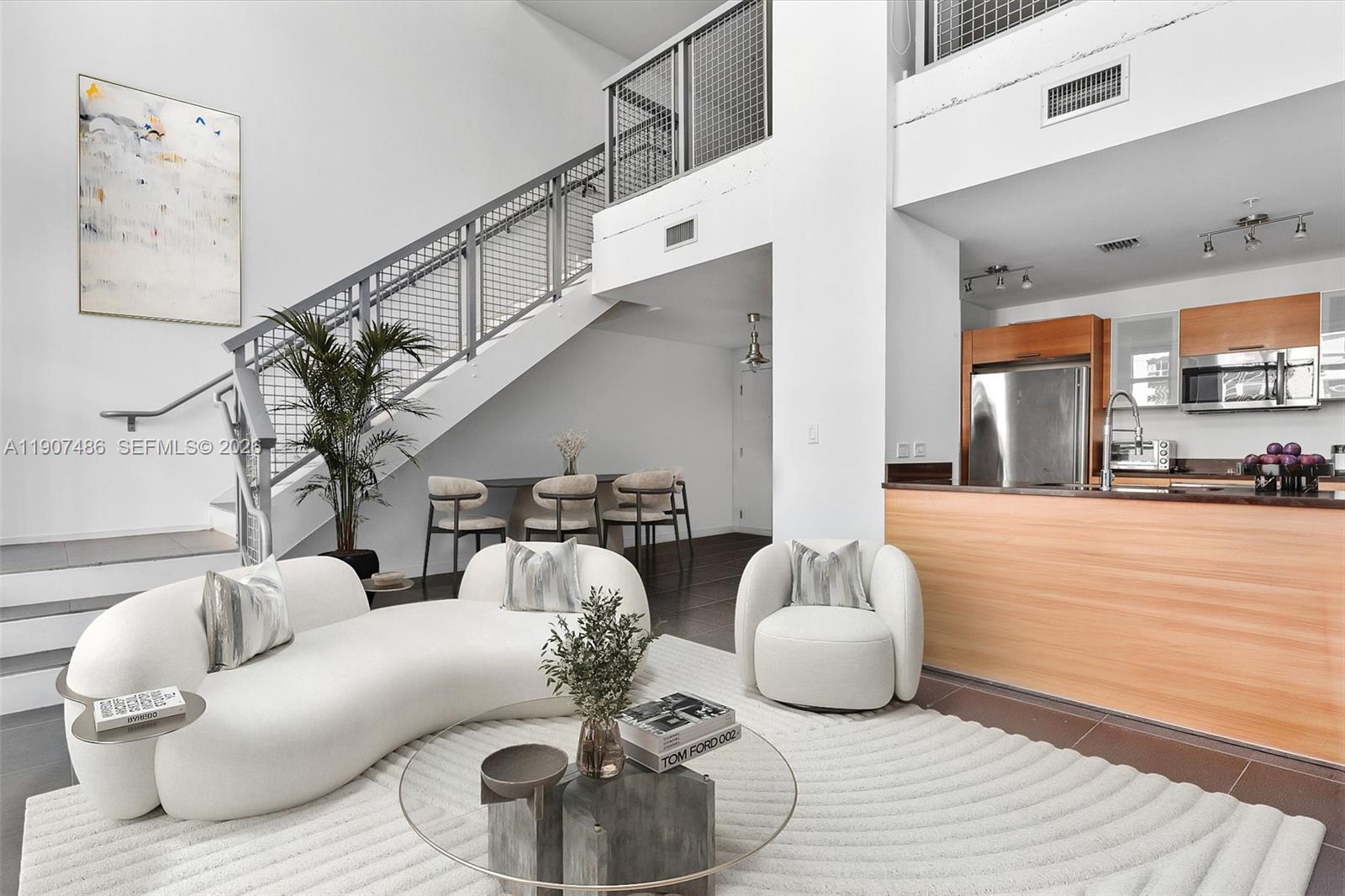 A modern, two-story loft apartment features a staircase, open kitchen, and white living room furniture — 3301 NE 1st Ave # M0502, Miami FL 33137, MIAMI, FL