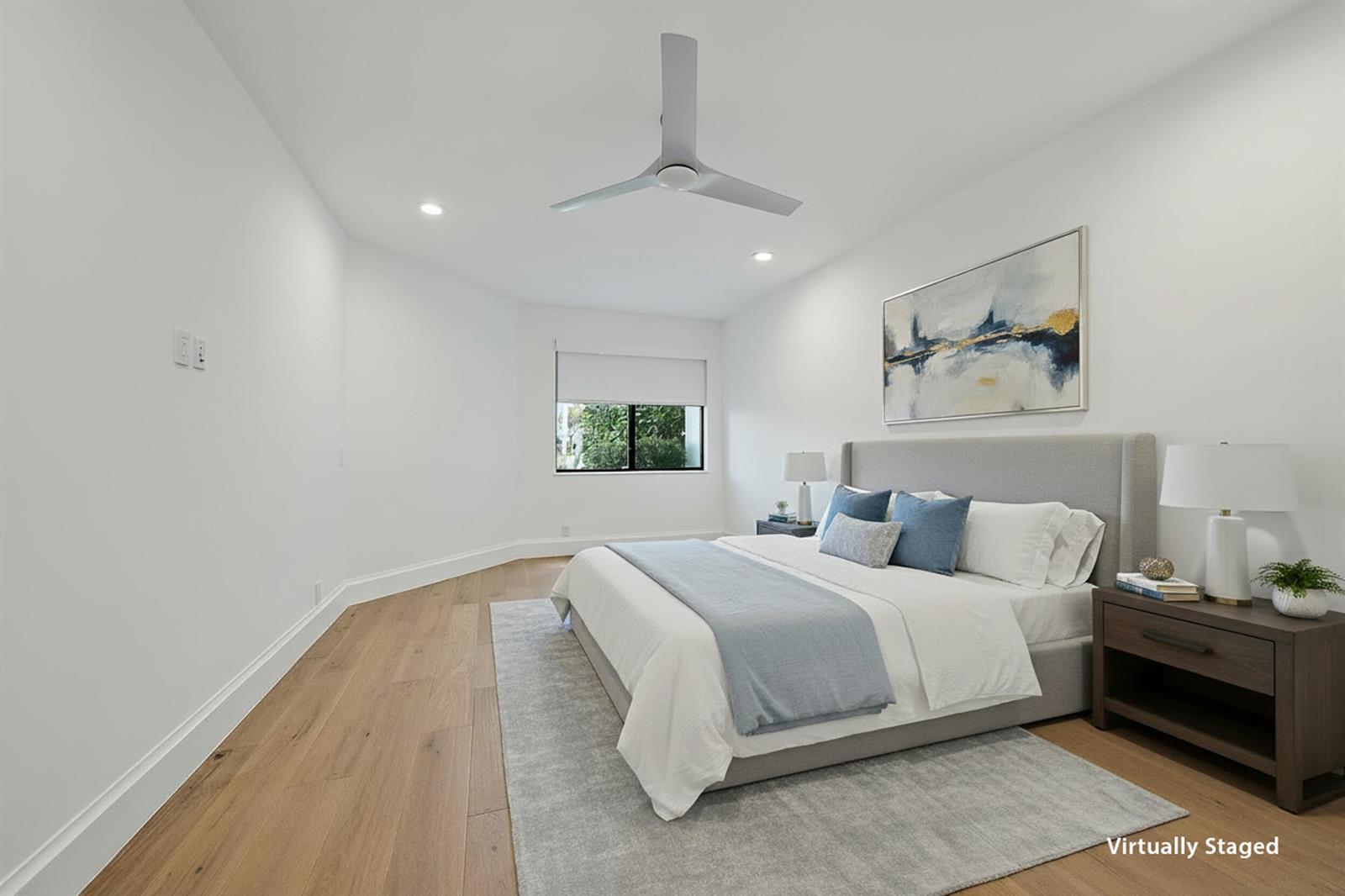 A virtually staged bedroom features light wood floors, a gray upholstered bed, and a ceiling fan — 108 Waters Edge Drive, Jupiter FL 33477, JUPITER, FL