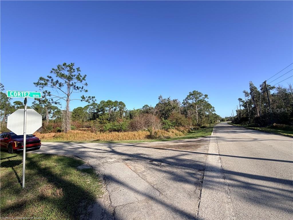 A street intersection features a stop sign and a street sign labeled Cortez Blvd — 5009 CORTEZ BOULEVARD, SEBRING, FL