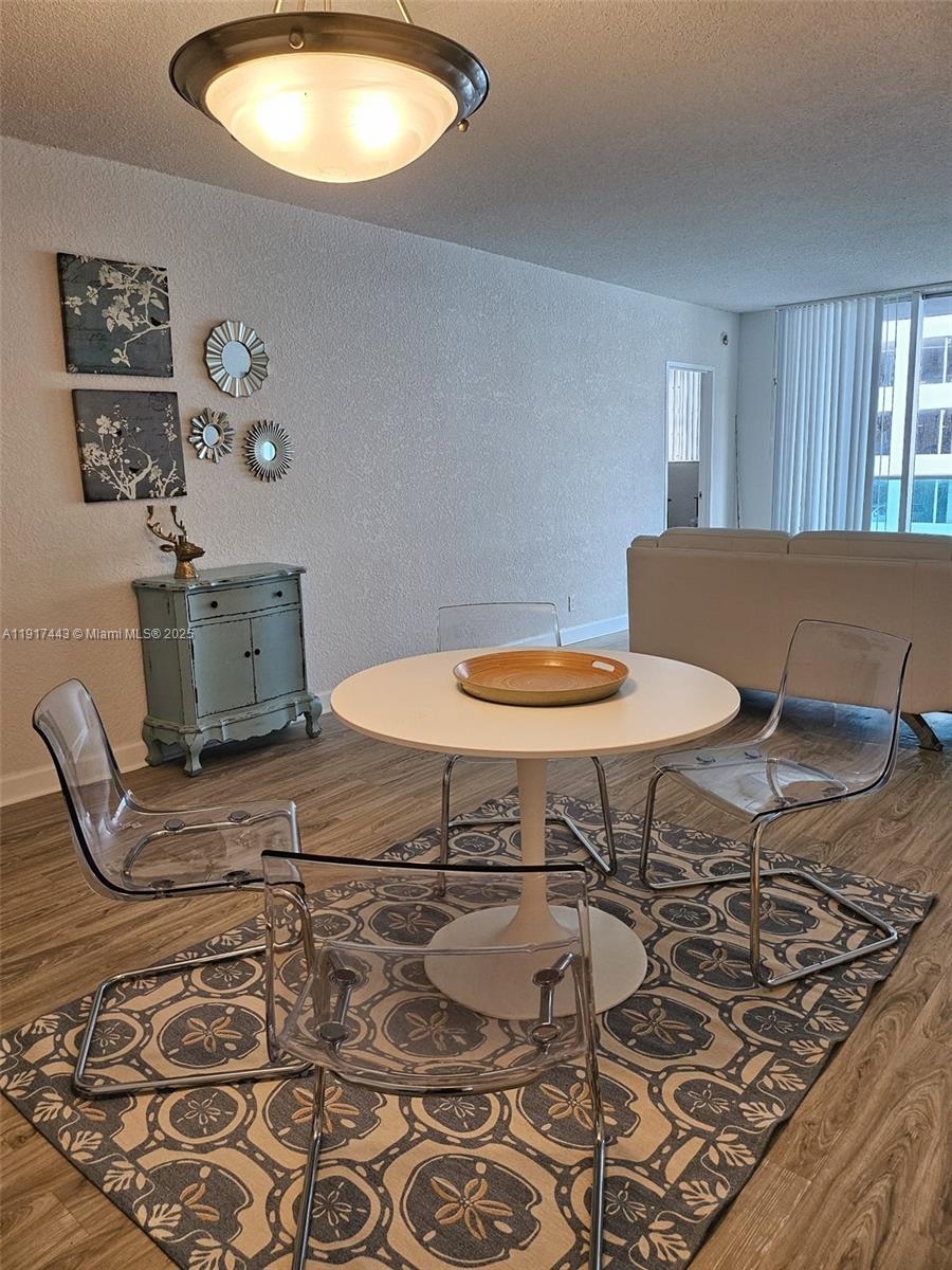 A dining area features a white pedestal table, clear chairs, and a patterned area rug — 4001 S OCEAN DR # 7F, Hollywood FL 33019, HOLLYWOOD, FL