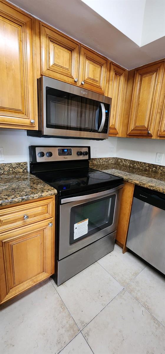 A kitchen features wood cabinets, granite countertops, and stainless steel appliances — 12154 Saint Andrews Pl # 110, Miramar FL 33025, MIRAMAR, FL