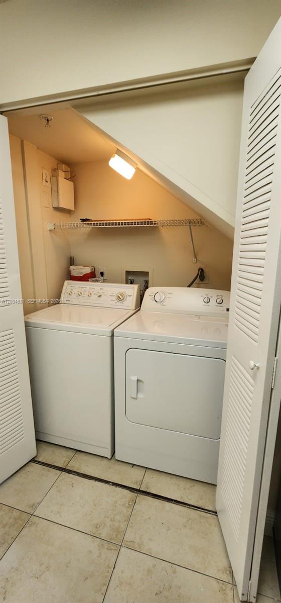 A laundry closet contains a white top-loading washing machine and a matching dryer — 12154 Saint Andrews Pl # 110, Miramar FL 33025, MIRAMAR, FL