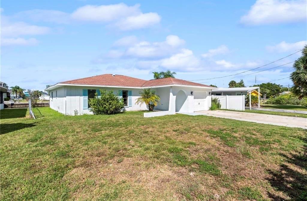 A single-story white house with a brown roof, blue shutters, and a concrete driveway — 3381 MINNOW CREEK DRIVE, HERNANDO BEACH, FL