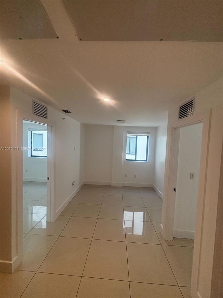 An interior view shows a tiled hallway leading to a room with two windows — 821 SW 18th Ave # 203, Miami FL 33135, MIAMI, FL