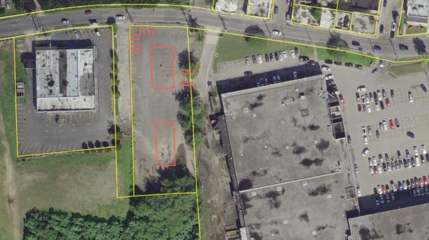 This aerial map shows a vacant rectangular lot outlined in yellow between two commercial buildings — 398 AVE. ROTARIOS, ARECIBO, PR