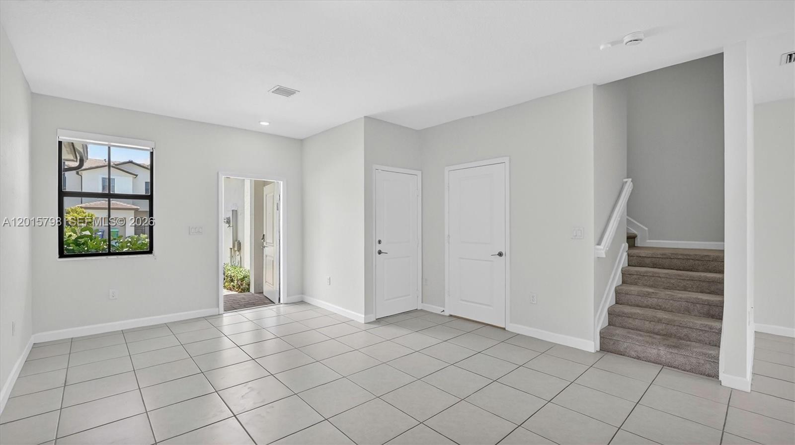 An interior view shows a tiled room with two doors, a window, and carpeted stairs — 23029 SW 128th Pl, Miami FL 33170, MIAMI, FL