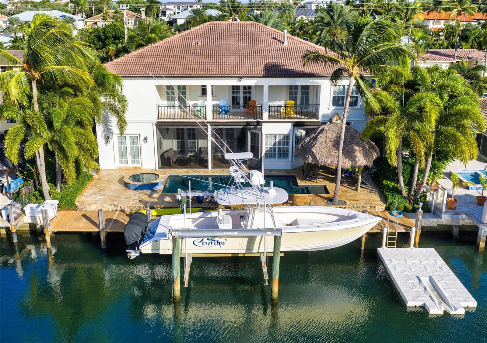 An aerial view shows a two-story house with a pool, boat lift, and palm trees — 3489 NE 30th Avenue, Lighthouse Point FL 33064, LIGHTHOUSE POINT, FL