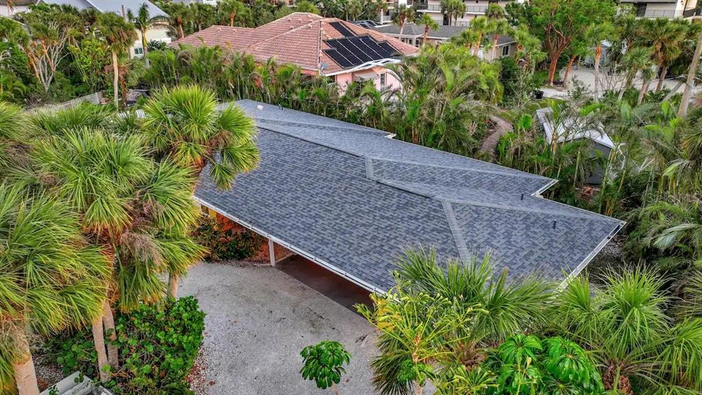 An aerial view shows a house with a gray shingled roof and a gravel driveway — 2795 A N BEACH ROAD UNIT #A, ENGLEWOOD, FL