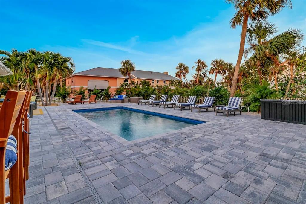A rectangular swimming pool is surrounded by a paved patio with lounge chairs and palm trees — 2795 A N BEACH ROAD UNIT #A, ENGLEWOOD, FL