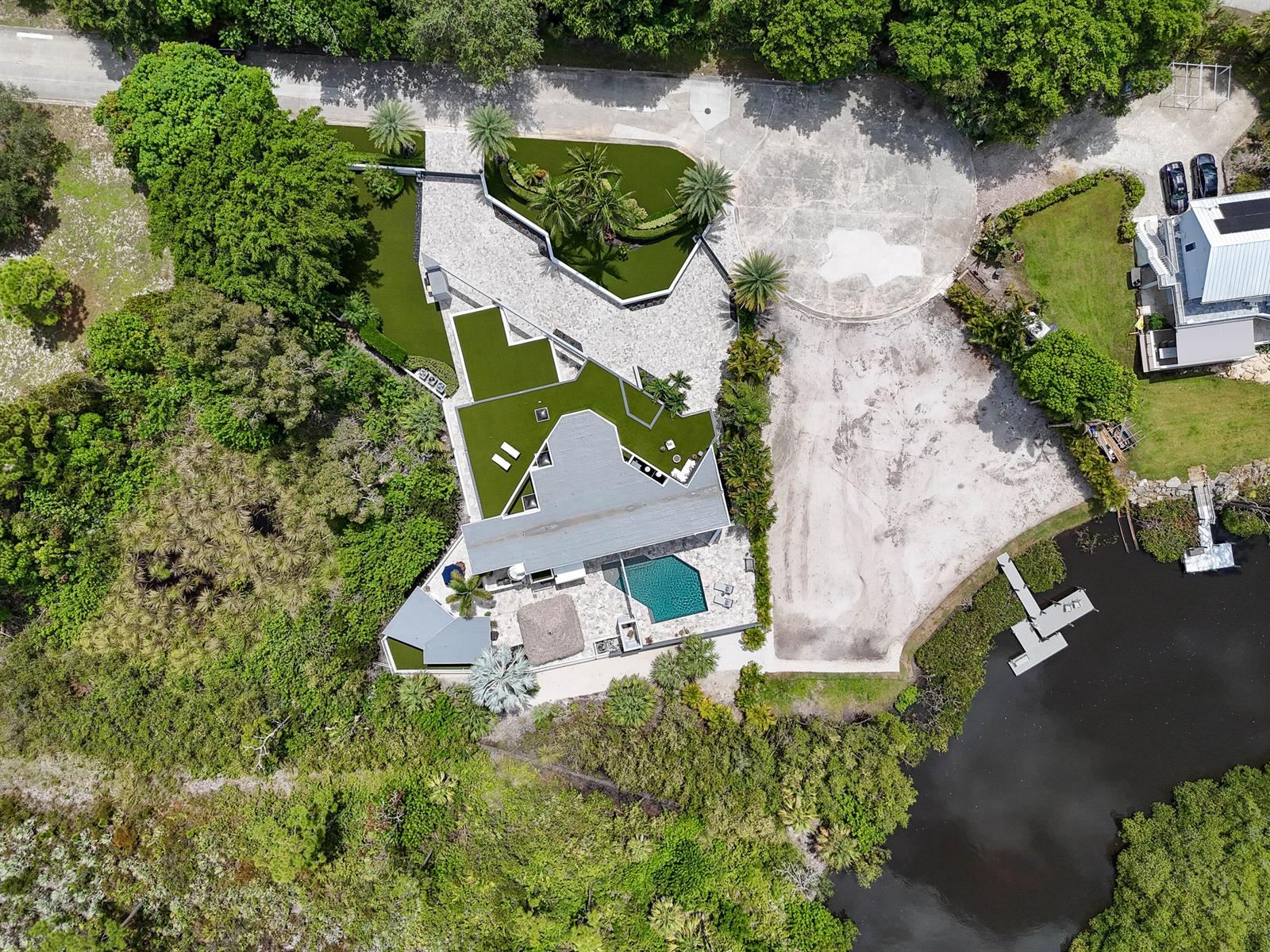 Aerial view of a modern house with a pool, patio, and large landscaped driveway — 10541 SE Le Parc, Jupiter FL 33469, JUPITER, FL