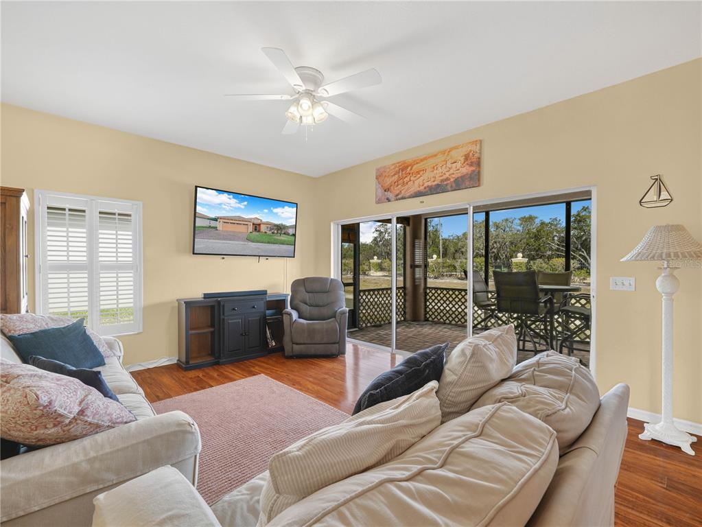 A living room features a television, a ceiling fan, and sliding doors to a patio — 4144 ABERDEEN LANE, LAKE WALES, FL
