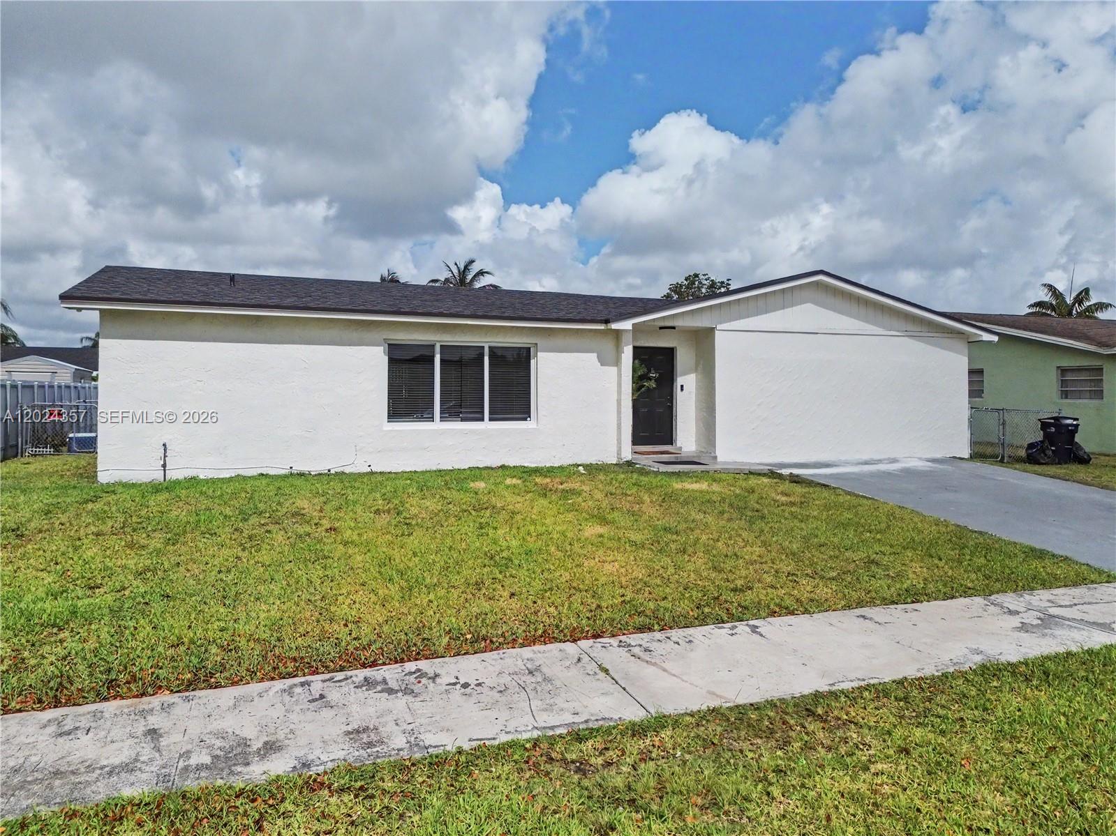 A single-story white house with a dark roof and a front-facing driveway — 16912 SW 107th Pl, Miami FL 33157, MIAMI, FL