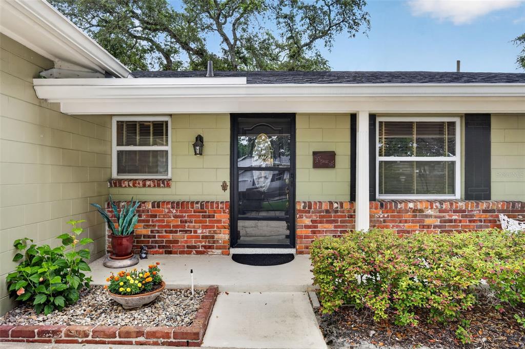 A single-story house exterior features light green siding, a brick base, and a front door — 2781 ABBEY ROAD, WINTER PARK, FL