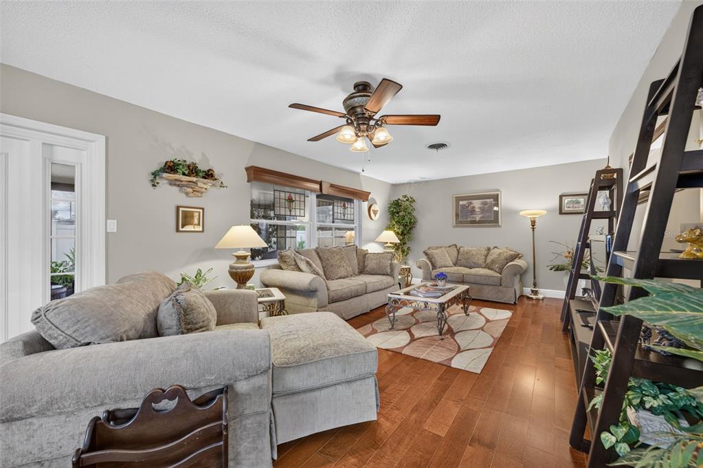 A living room with hardwood floors, a ceiling fan, and two matching fabric sofas — 2781 ABBEY ROAD, WINTER PARK, FL