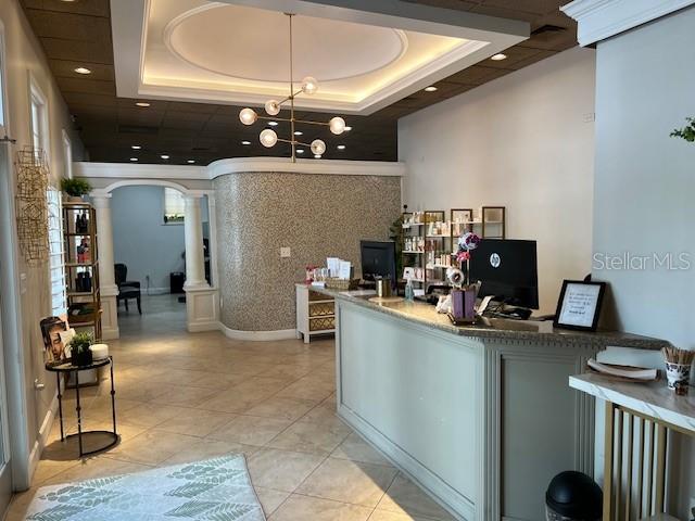 A reception area features a curved wall, a long service desk, and a modern chandelier — 5207 SW SW 91ST TERRACE, GAINESVILLE, FL