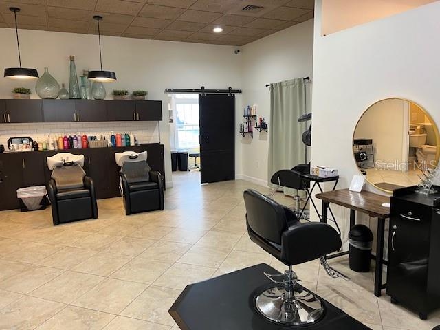 A hair salon features two shampoo stations, a styling chair, and dark cabinetry — 5207 SW SW 91ST TERRACE, GAINESVILLE, FL