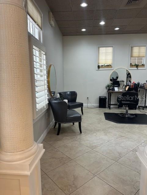 A salon room features two dark chairs, a styling station with a mirror, and tile flooring — 5207 SW SW 91ST TERRACE, GAINESVILLE, FL