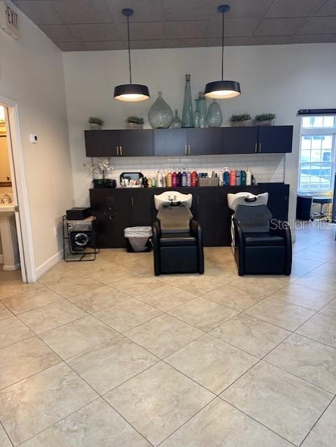 This salon features two black shampoo chairs, dark cabinetry, and two pendant lights — 5207 SW SW 91ST TERRACE, GAINESVILLE, FL