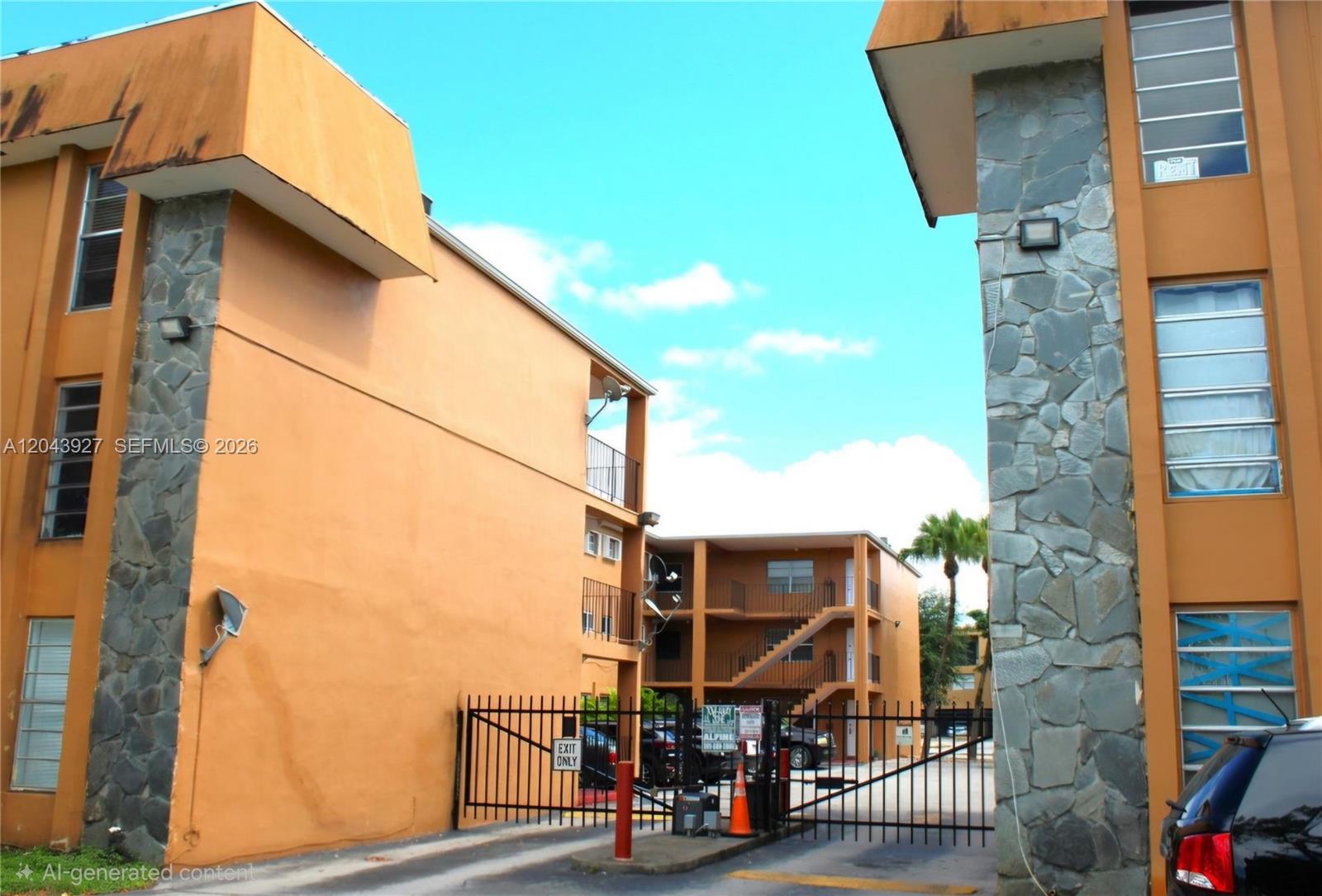 The exterior of a multi-story apartment complex features orange stucco walls and stone accents — 1230 W 54th St # 218A, Hialeah FL 33012, HIALEAH, FL