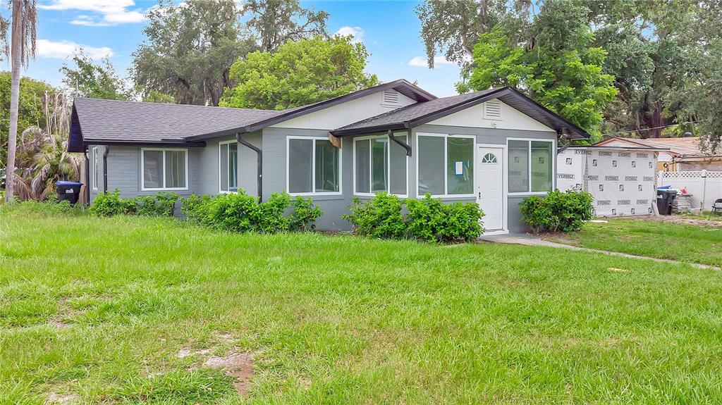 A gray, single-story house with a dark roof and white trim sits on a grassy lot — 3504 S NASHVILLE AVENUE, ORLANDO, FL