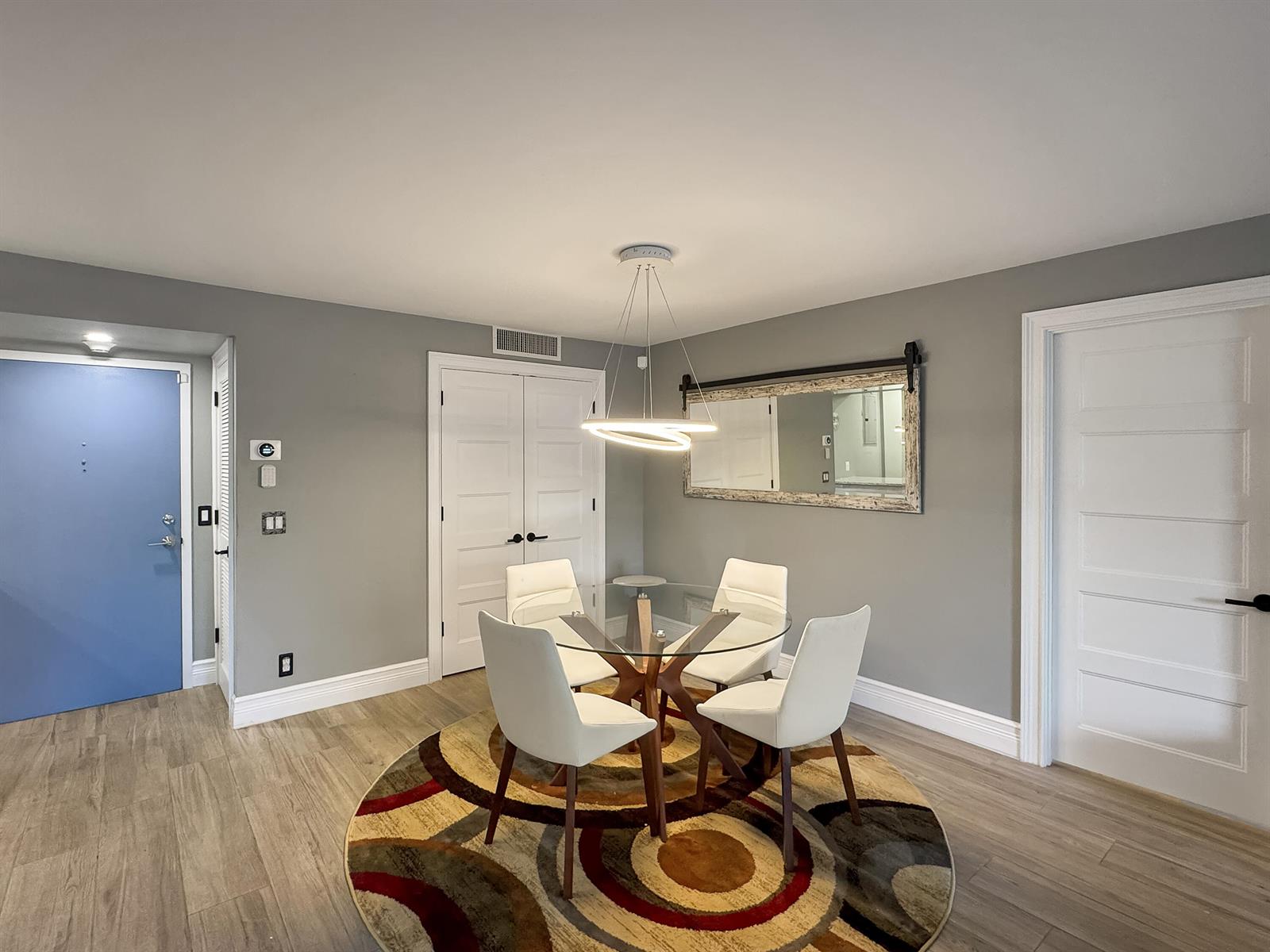 A dining area features a glass table, four white chairs, and a patterned circular rug — 2000 S Ocean Boulevard, Pompano Beach FL 33062, POMPANO BEACH, FL