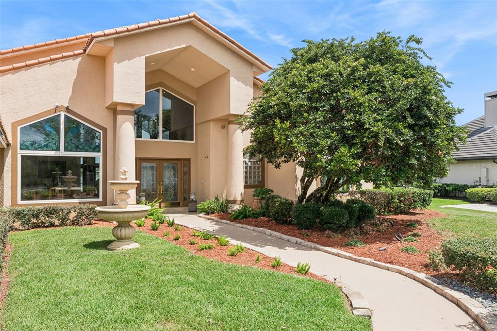 An aerial view shows a waterfront house with a red roof and private dock — 2617 BUTLER BAY DRIVE N, WINDERMERE, FL