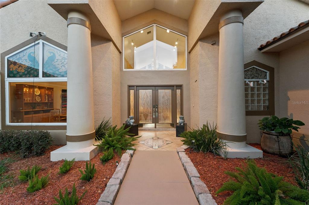 A screened-in swimming pool and spa overlook a lake with a private dock — 2617 BUTLER BAY DRIVE N, WINDERMERE, FL