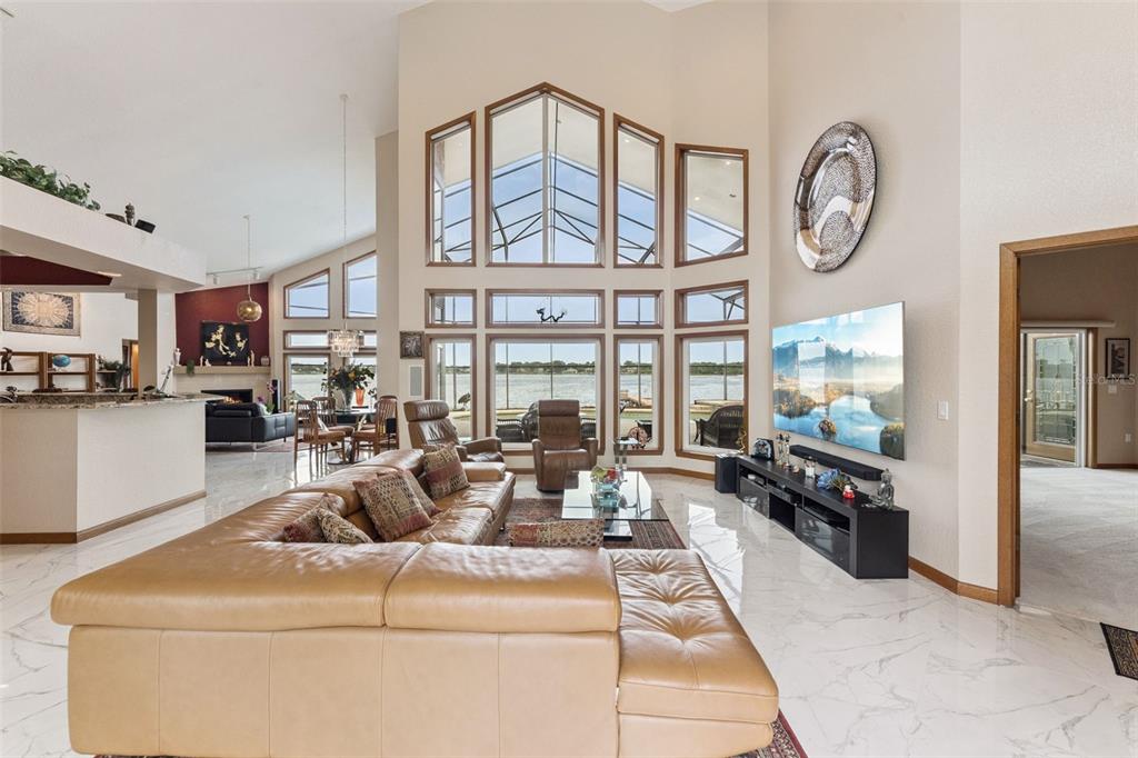 A screened-in pool and hot tub overlook a lake with a private dock — 2617 BUTLER BAY DRIVE N, WINDERMERE, FL