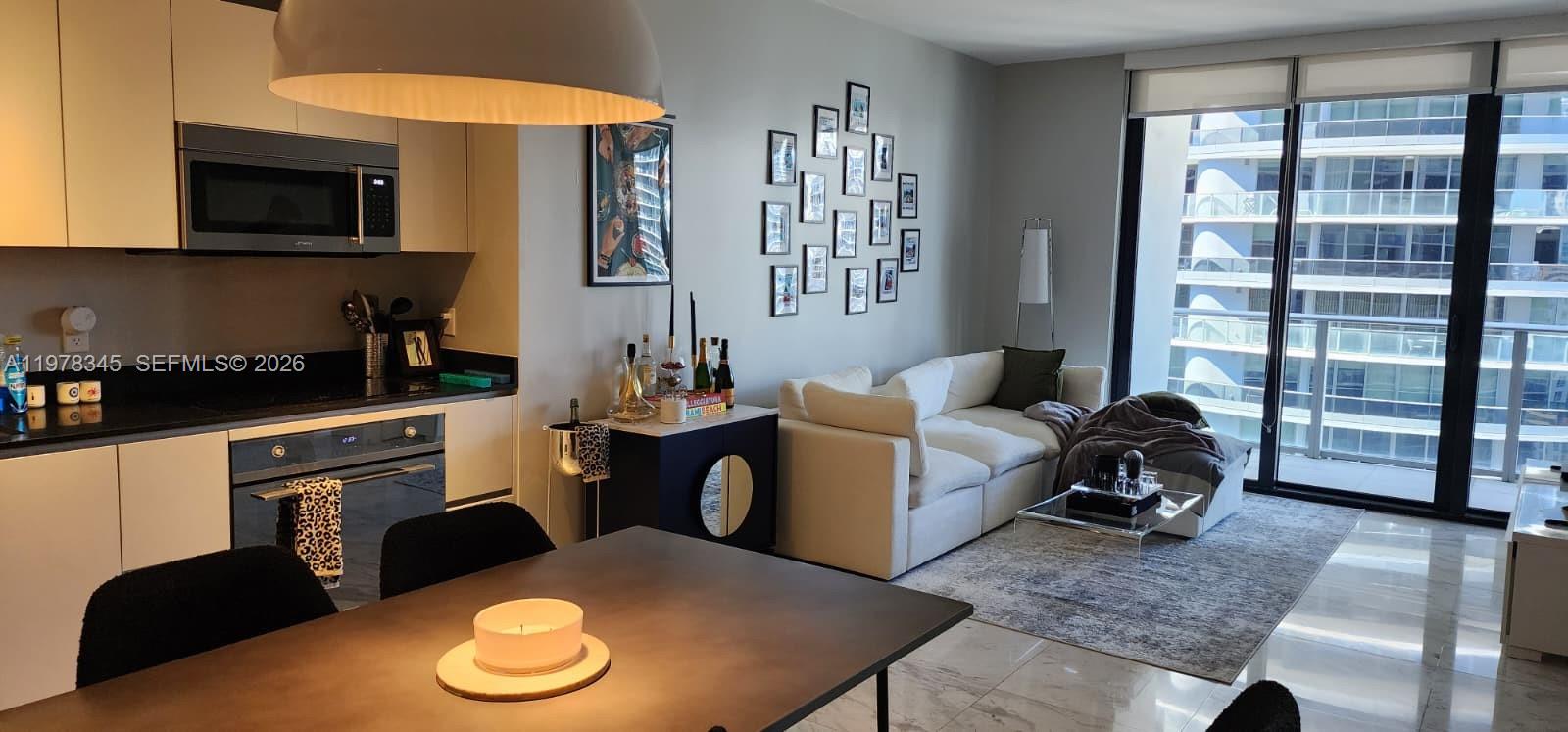 A modern apartment features an open-concept kitchen, dining area, and living room with balcony access — 1010 Brickell Ave # 4208, Miami FL 33131, MIAMI, FL