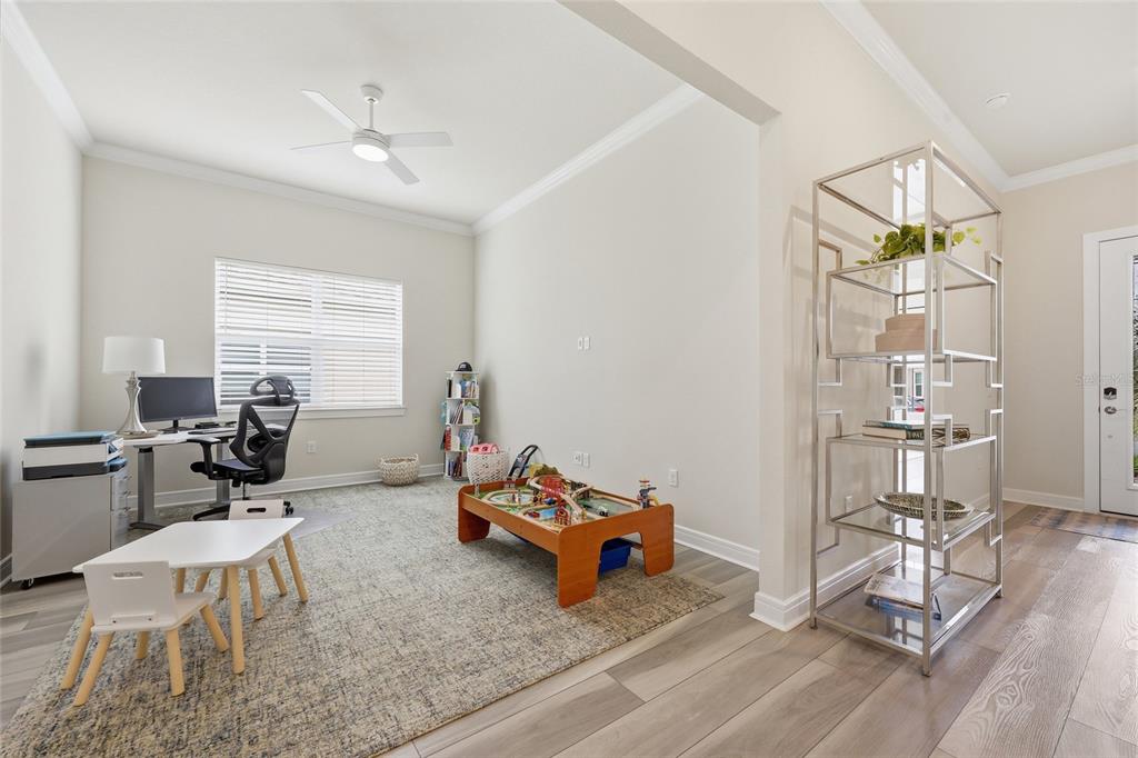 A multi-purpose room features a desk, a child's play table, and a tall metal shelving unit — 15031 CANOPY COVER DRIVE, WINTER GARDEN, FL