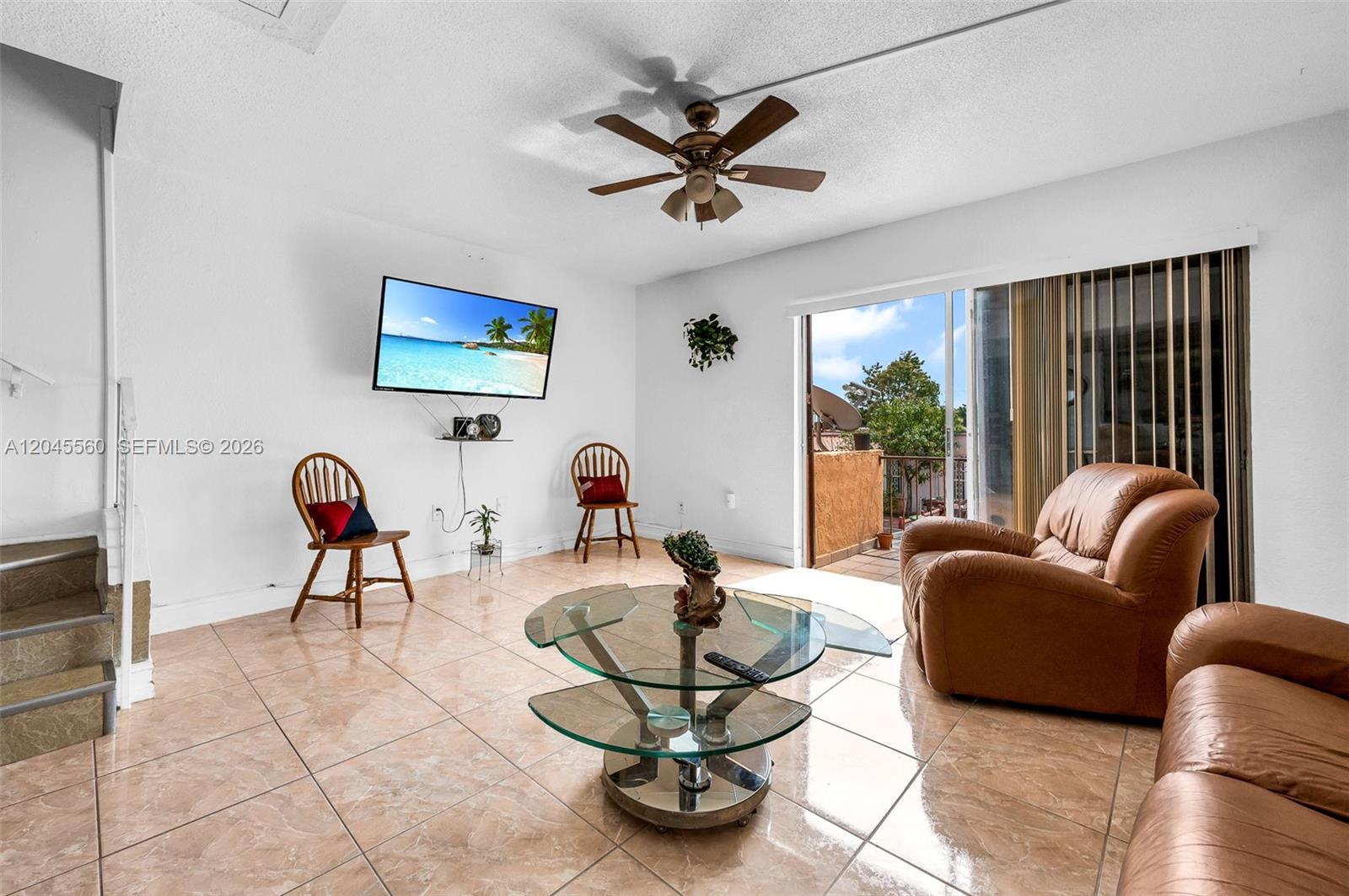 A living room features tile flooring, a glass coffee table, leather seating, and a balcony — 6600 W 2nd Ct # 24, Hialeah FL 33012, HIALEAH, FL