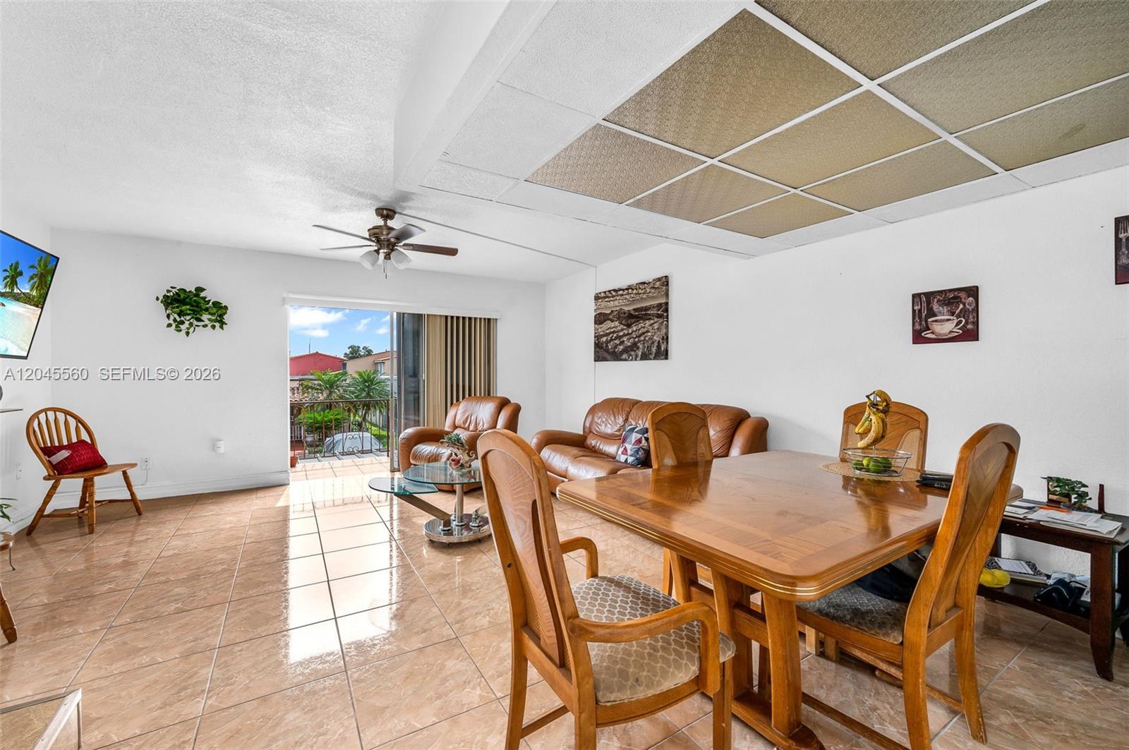 A living and dining area features tile flooring, a drop ceiling, and a sliding glass door — 6600 W 2nd Ct # 24, Hialeah FL 33012, HIALEAH, FL