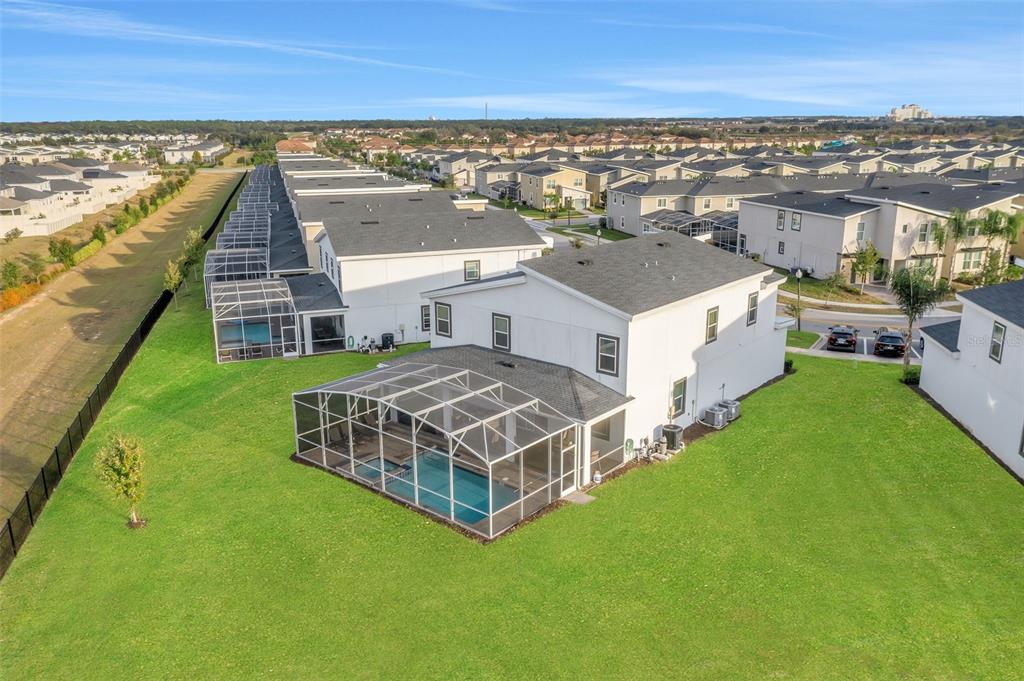 An aerial view shows a two-story house with a screened-in pool and a large lawn — 9262 SOMMERSET HILLS DRIVE, DAVENPORT, FL