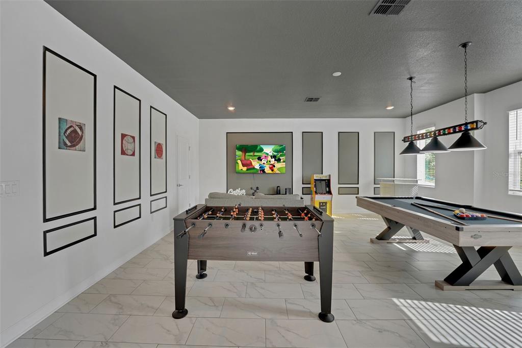A game room features a foosball table, a pool table, and a wall-mounted television — 9262 SOMMERSET HILLS DRIVE, DAVENPORT, FL