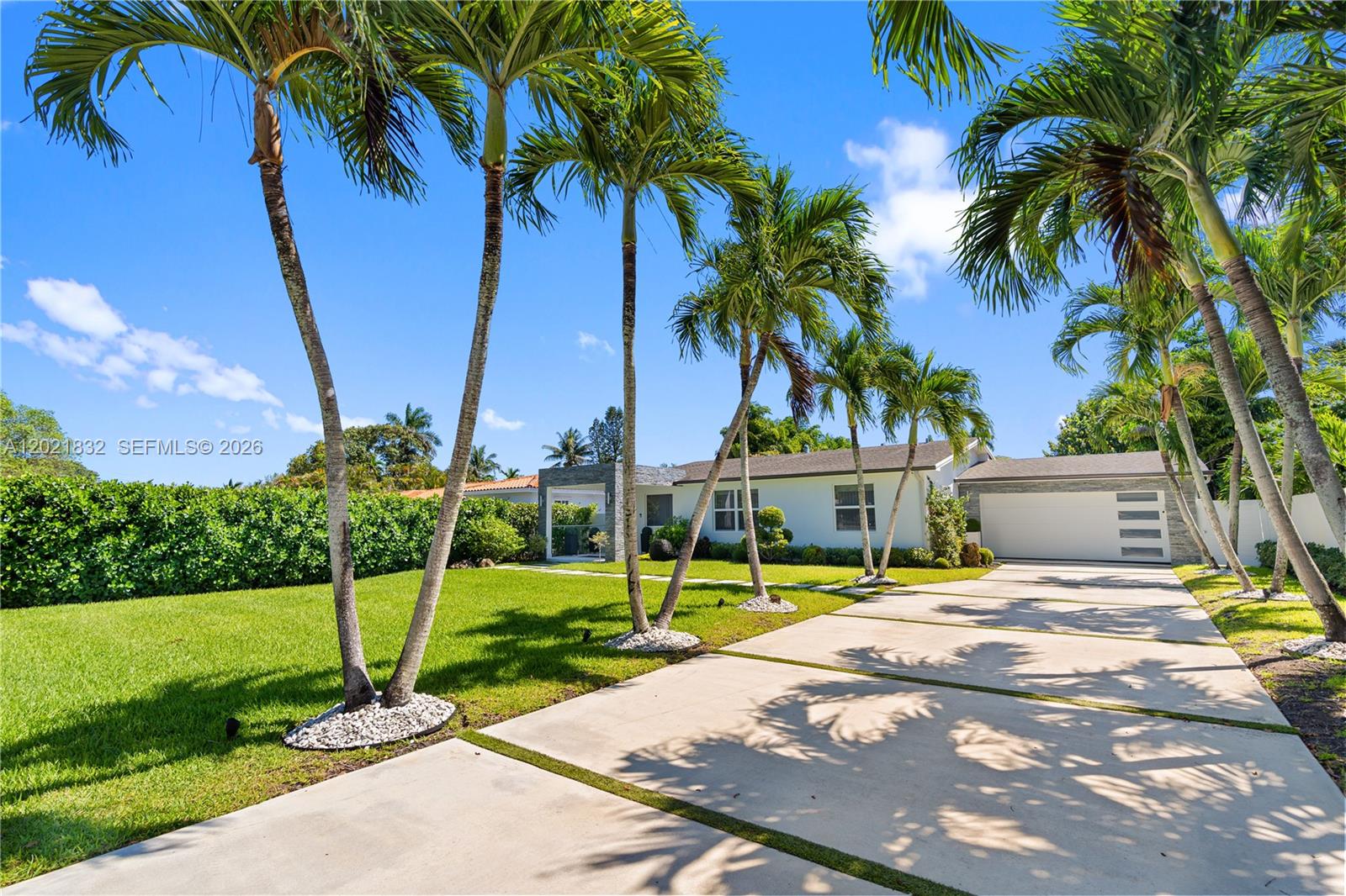A covered front porch overlooks a grassy yard with a stone path and palm trees — 14441 S Biscayne River Rd, Miami FL 33161, MIAMI, FL