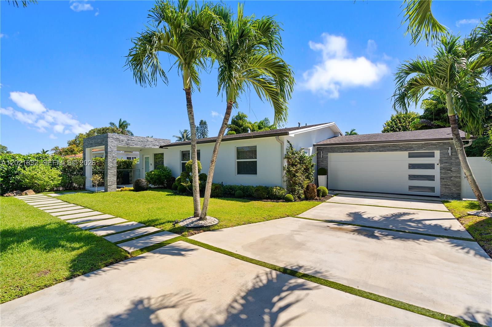 A single-story house with a concrete driveway and palm trees sits on a grassy lot — 14441 S Biscayne River Rd, Miami FL 33161, MIAMI, FL