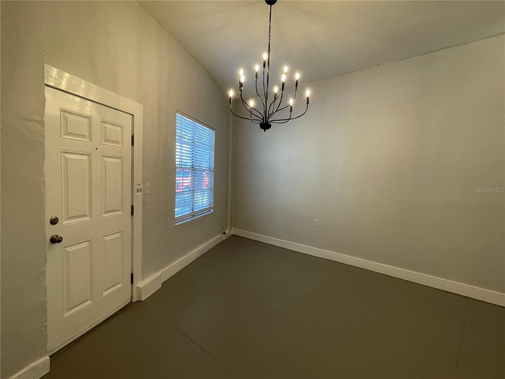 This living and dining area features sage green walls, a gray sectional, and wood furniture — 2305 W TEXAS AVENUE UNIT 5, TAMPA, FL