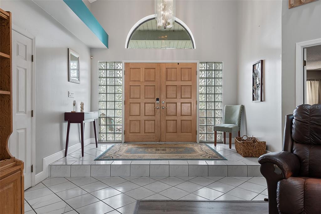 An entryway features a double wood door, glass block windows, and a raised tiled floor — 3 ECHO WOODS WAY, ORMOND BEACH, FL