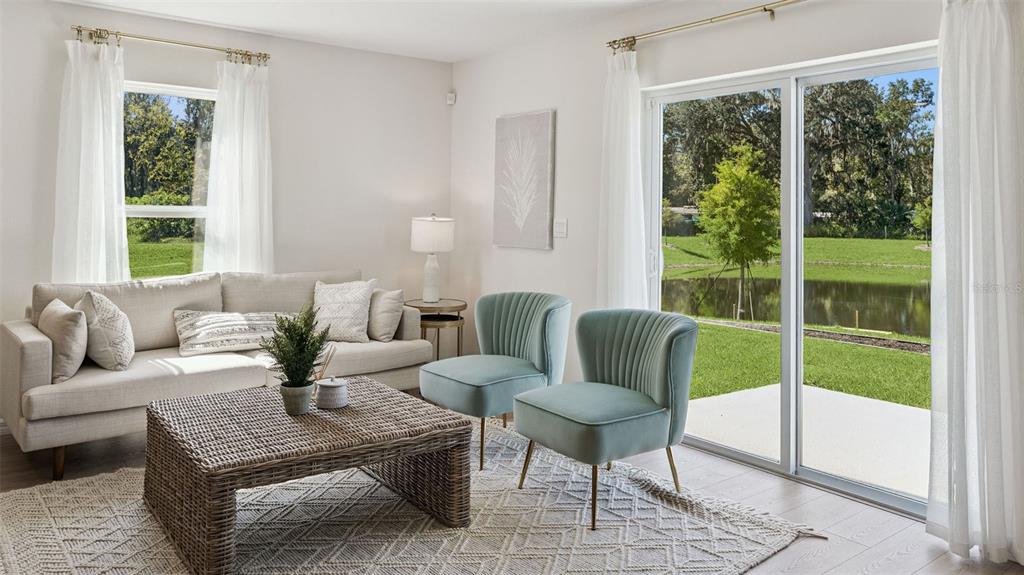 A living room features a beige sofa, two light blue chairs, and a sliding glass door — 725 PRESTON COVE DRIVE, ST CLOUD, FL