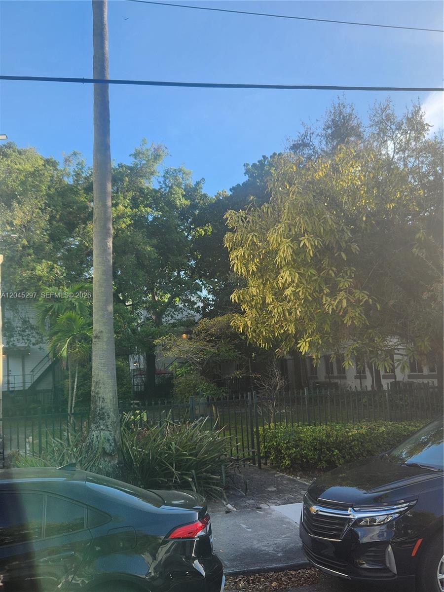 A tall palm tree stands in front of a house obscured by trees and fencing — 412 NW 4th St, Miami FL 33130, MIAMI, FL