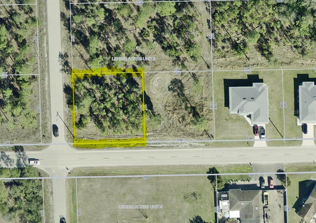 This is an aerial map showing a rectangular vacant lot highlighted in yellow — 2101 E 10TH STREET, LEHIGH ACRES, FL